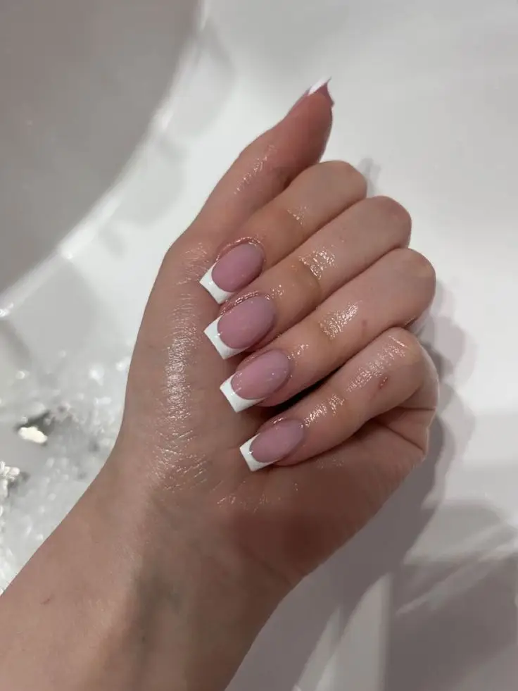 Soft latte-toned acrylic short nails with subtle glitter accents