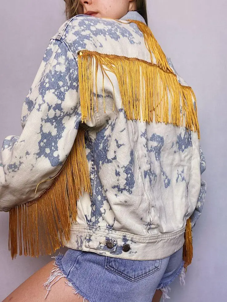 Denim jacket with striped ribbon details along the sleeves and back seams