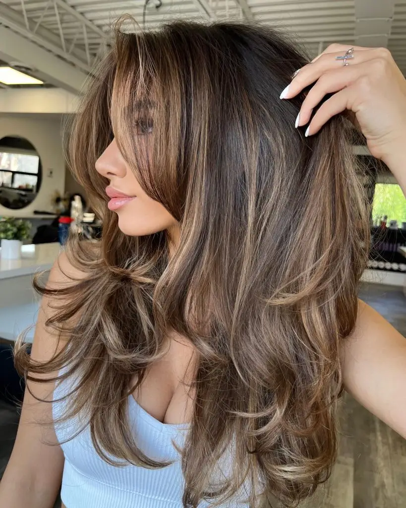 Classic waves paired with bold caramel streaks on brown hair