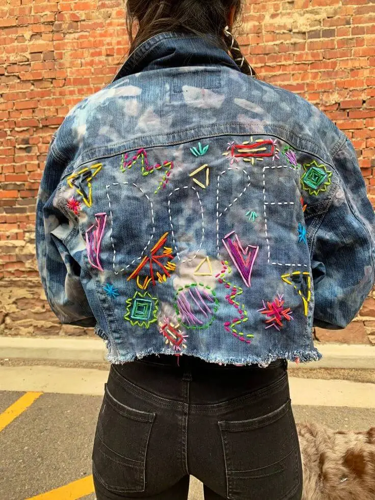 Denim jacket showcasing hand-painted floral ombre patterns