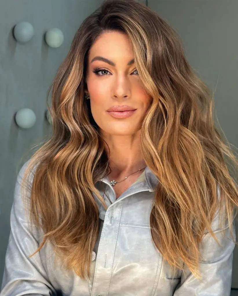 Voluminous curls with lush toffee-caramel highlights on brown hair