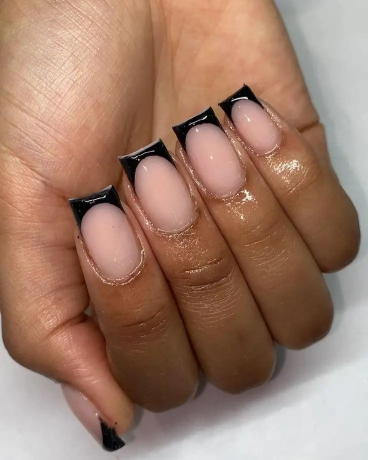 Short acrylic nails coated in pearlized chrome with a sleek, shiny finish