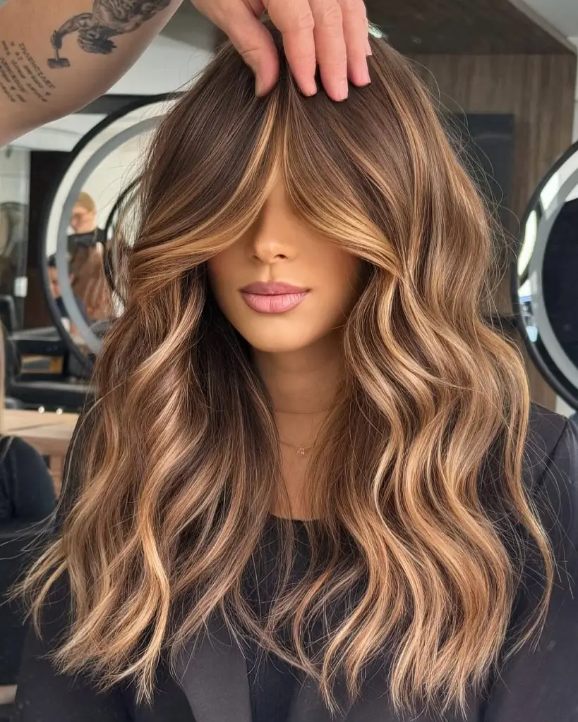 Classic blowout with honeyed caramel streaks in brunette hair