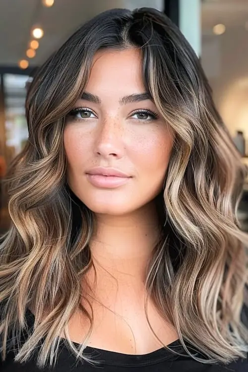 Dark brown hair with caramel blonde face-framing highlights for a glow-up effect