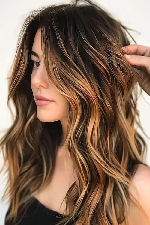Rich tawny highlights adding soft dimension to dark brown hair