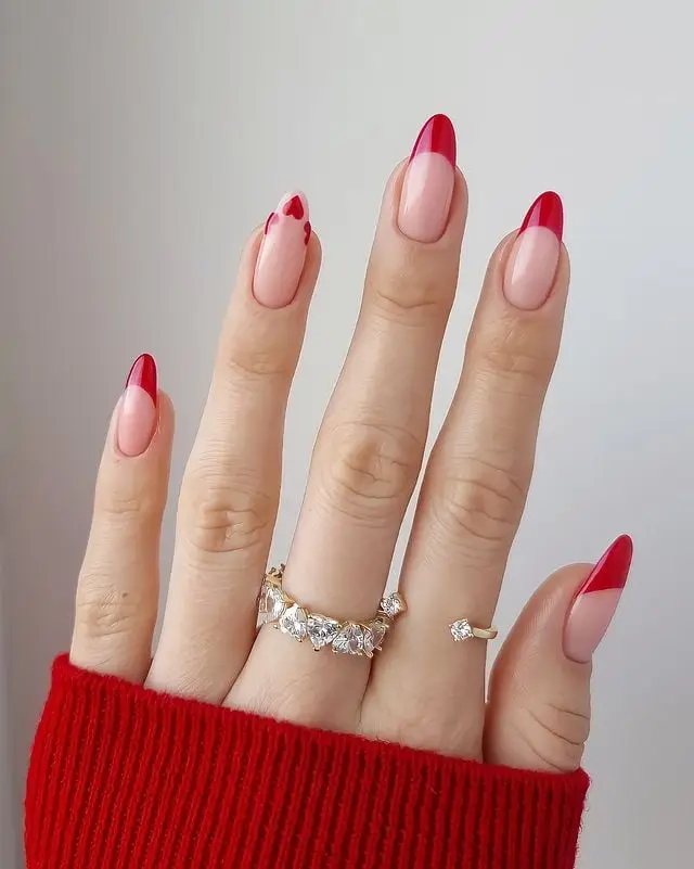 Nude nails with red heart-shaped French tips