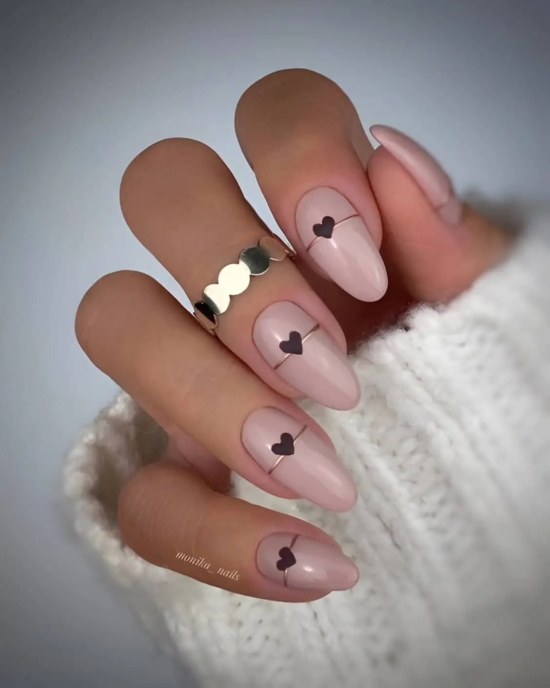 Pink acrylic Valentine’s nails with soft glitter accents and heart embellishments