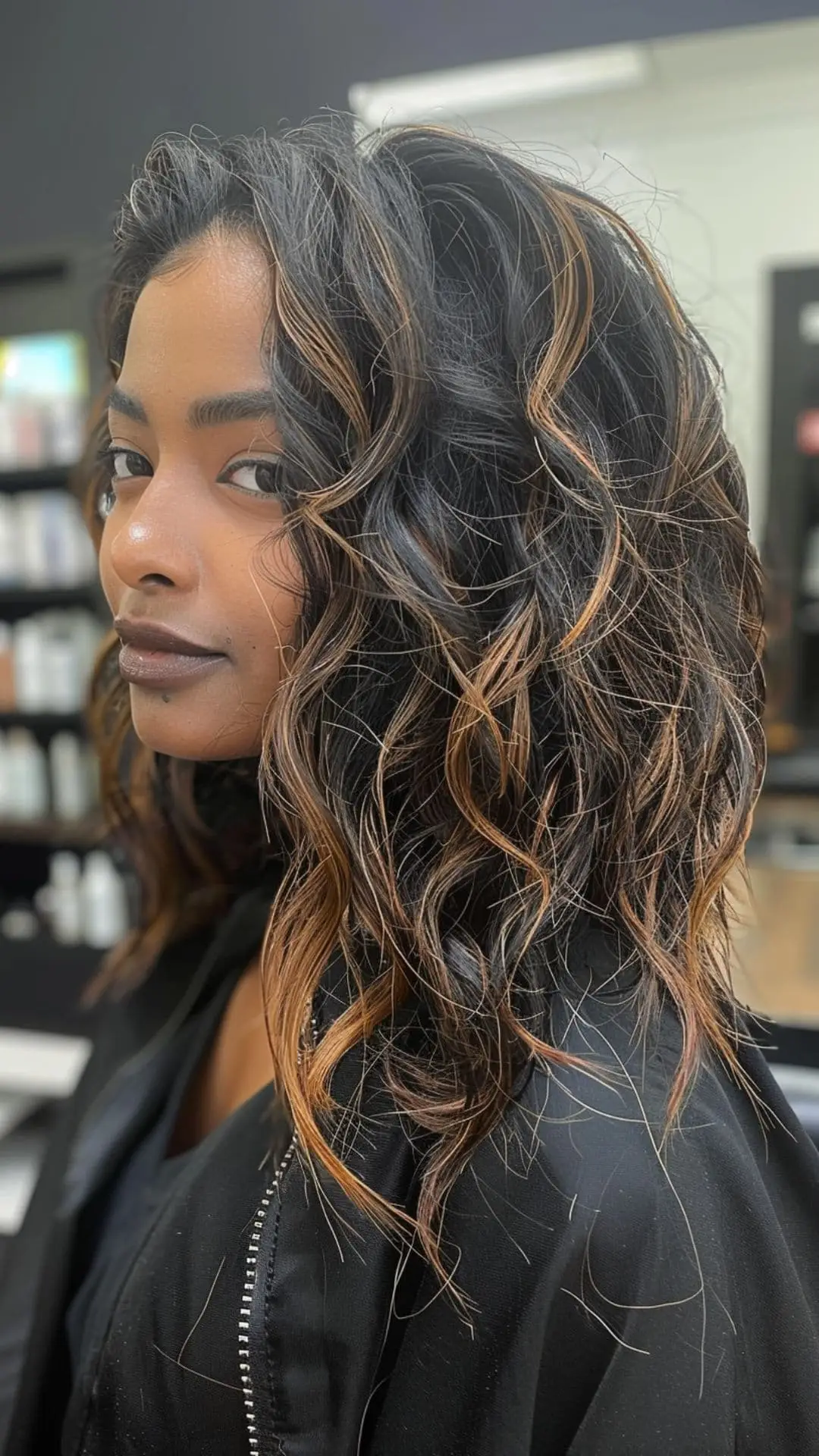 Glossy black hair with rich caramel highlights in smooth layers