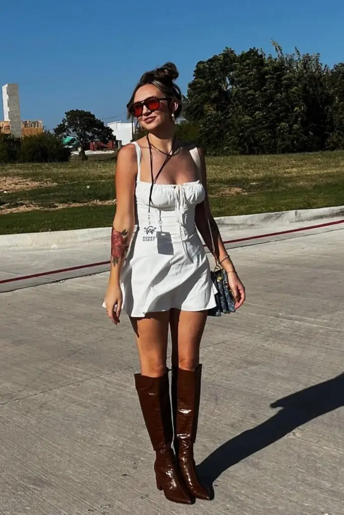 Woman in black leather jacket, white crop top, and stylish cowboy hat