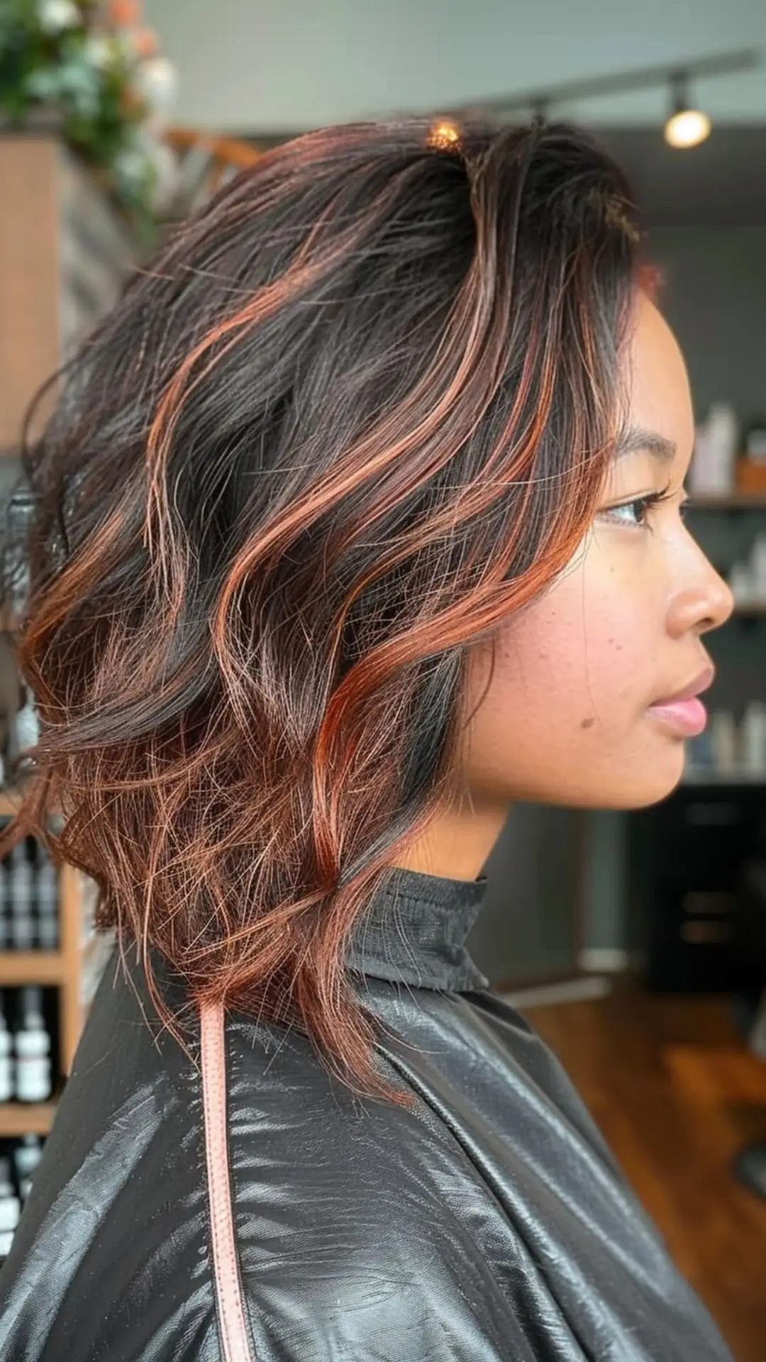 Glossy black hair with vibrant copper highlights adding fiery warmth