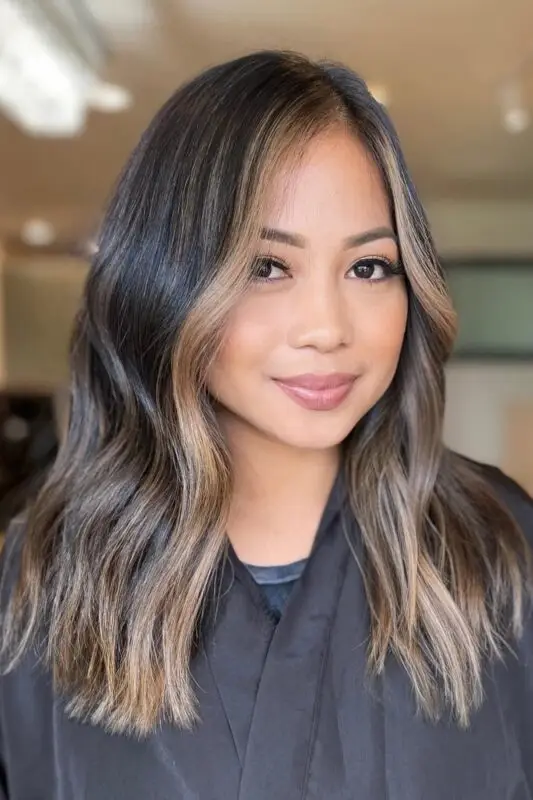 Black hair with honey blonde highlights creating a striking contrast