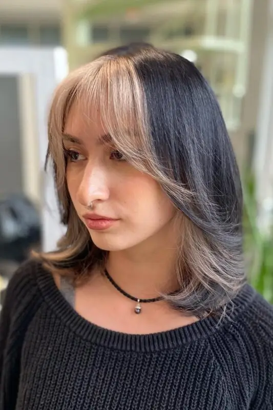 Black hair with blonde front highlights creating a striking focal point