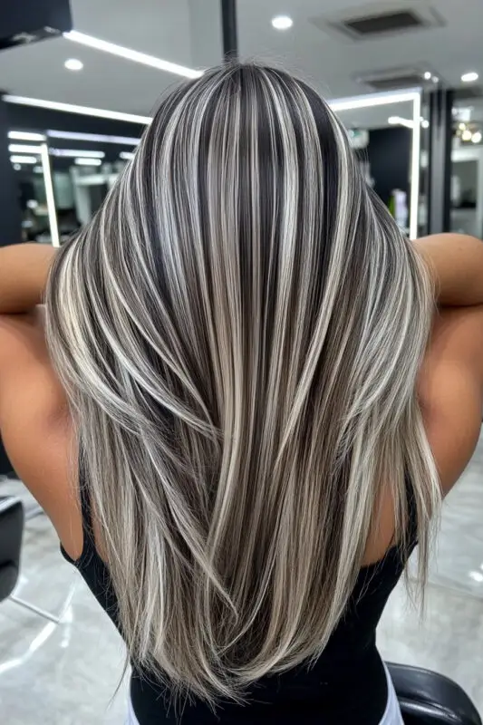 Black hair with bold blonde foil highlights for a dramatic effect
