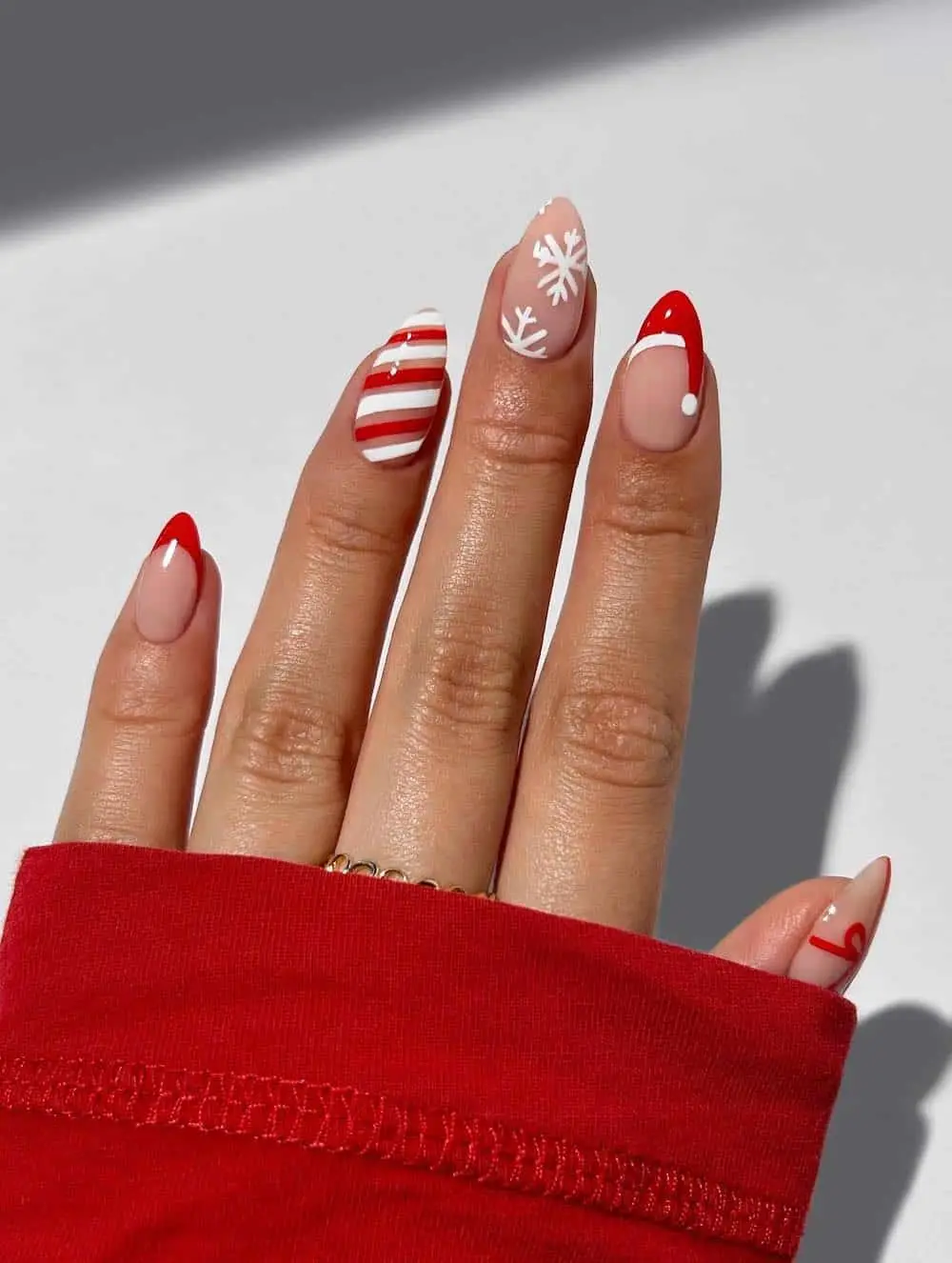 Abstract Christmas-themed nail design with red, green, and nude tones