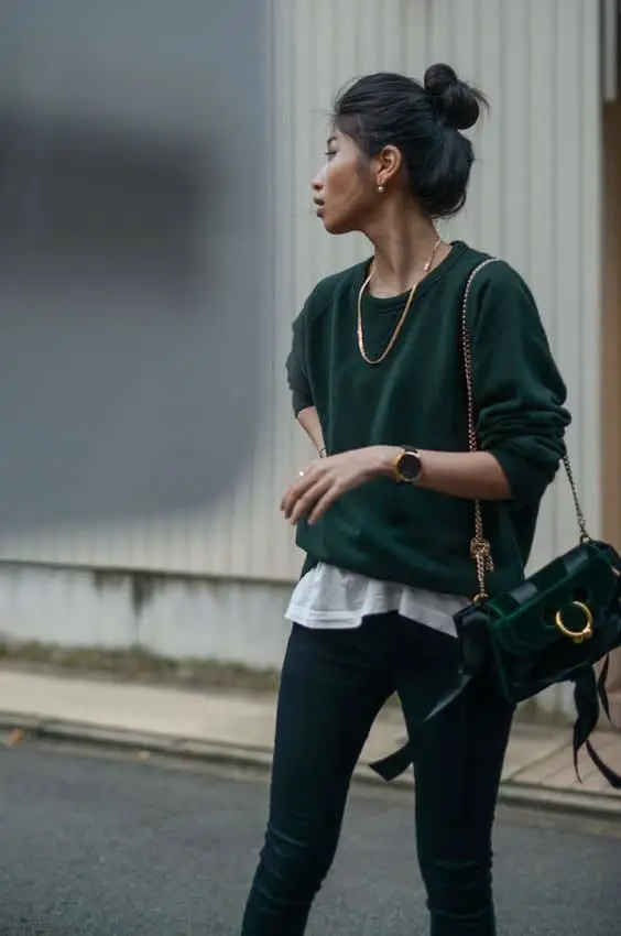 Layered olive green sweater paired with black skinny jeans for a casual Saint Patrick's Day outfit