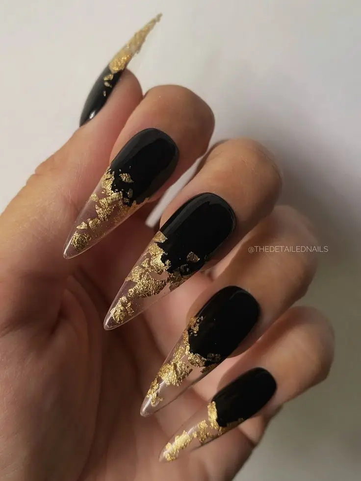 Black nails with heart-shaped cutouts and glitter