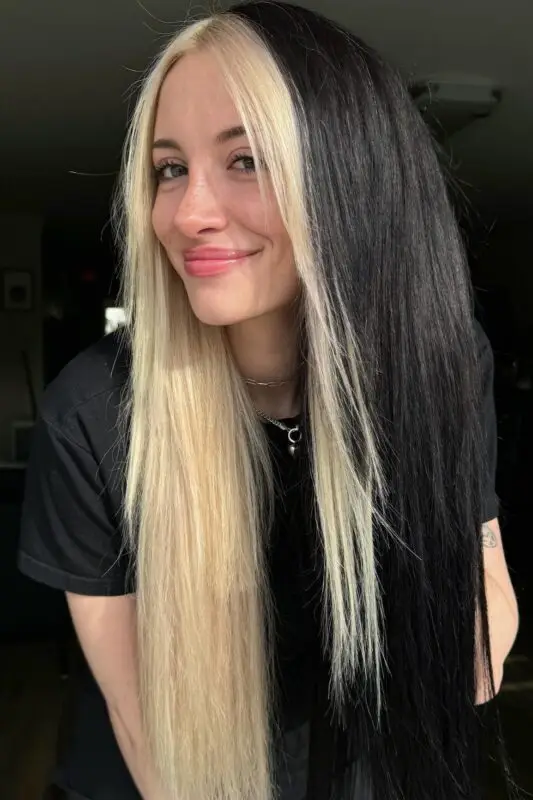 Split-dye hairstyle with half-black and half-blonde color for a bold dual-tone look