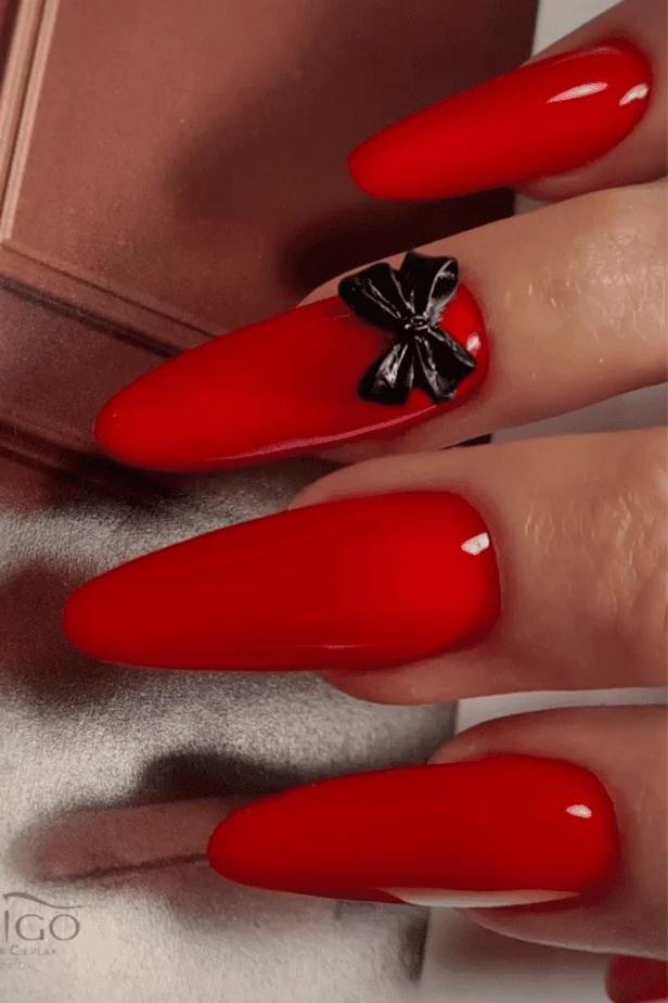 Long, glossy red acrylic nails with minimalist accents