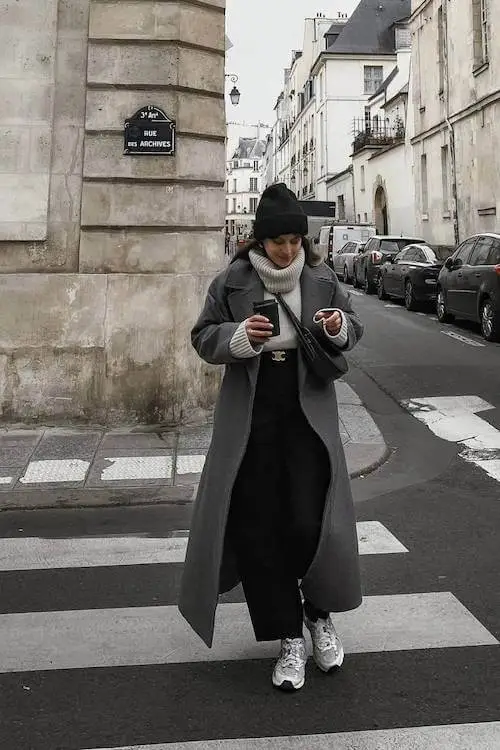 Relaxed winter outfit featuring an oversized coat and scarf with sneakers