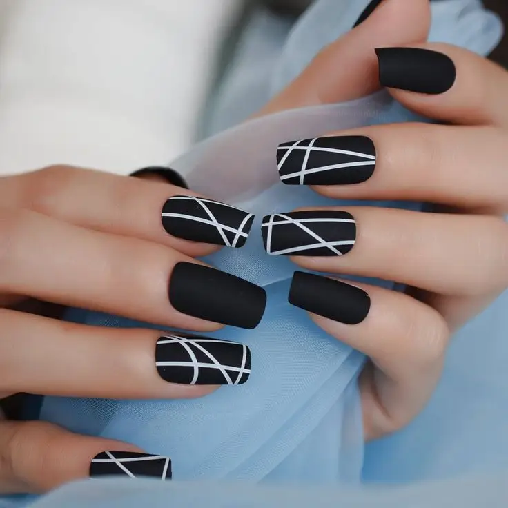 Short acrylic nails in a neutral stone-inspired palette with white veins