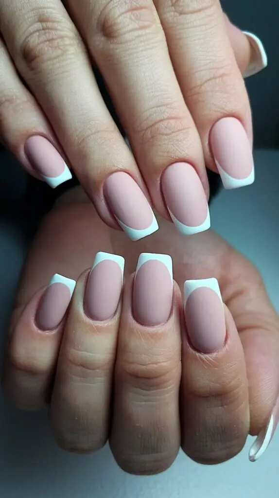 Short muted jewel-toned nails with glitter highlights