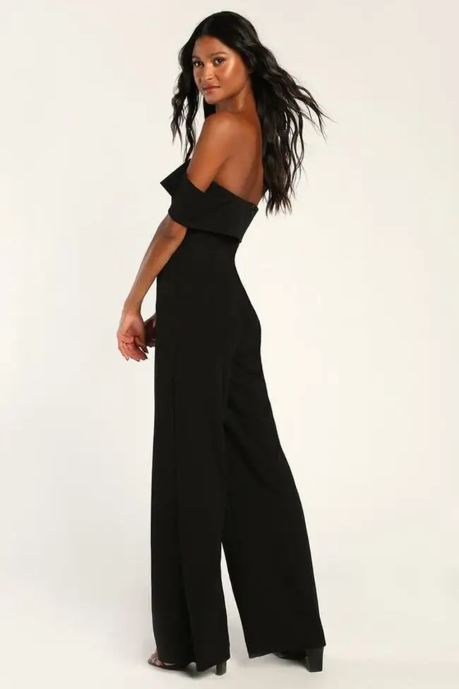 Black woman wearing an orange satin wrap dress with strappy gold sandals