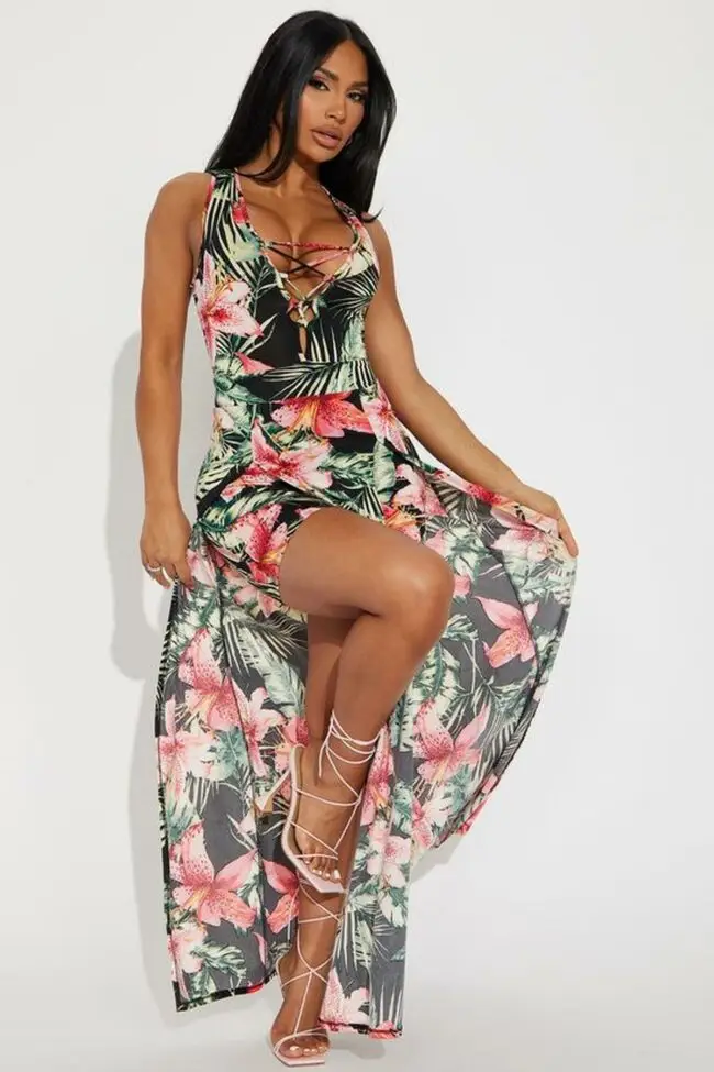 Black woman wearing a floral A-line mini dress styled with bold red accessories