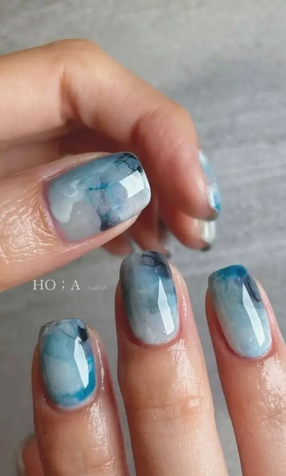 Short neon green acrylic nails with abstract white swirls