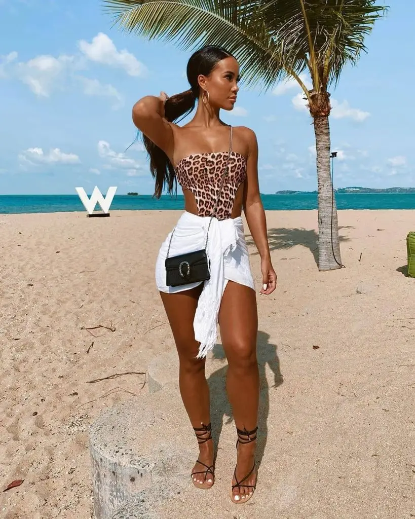 Black woman in a blue ruffled playsuit styled with white sneakers