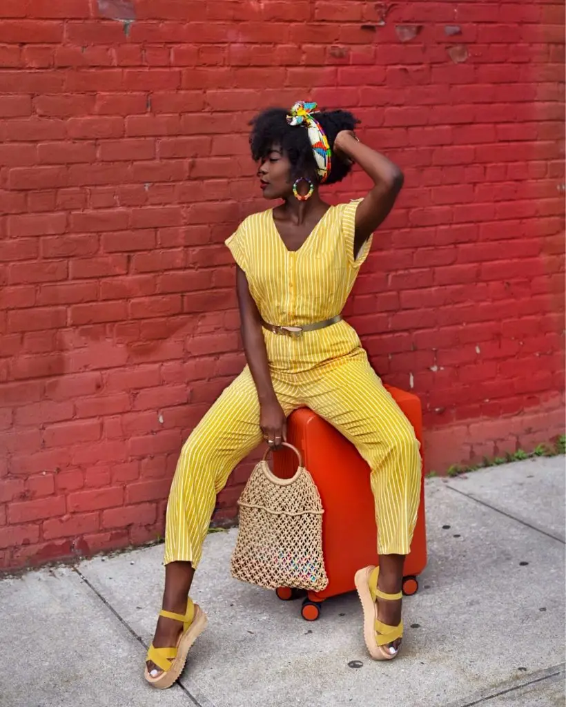 Black woman in a relaxed taupe belted jumpsuit with wide-leg pants
