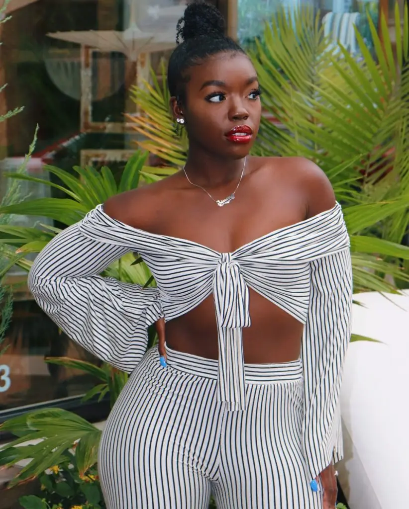Black woman wearing an oversized olive green two-piece set with a matching shirt and pants