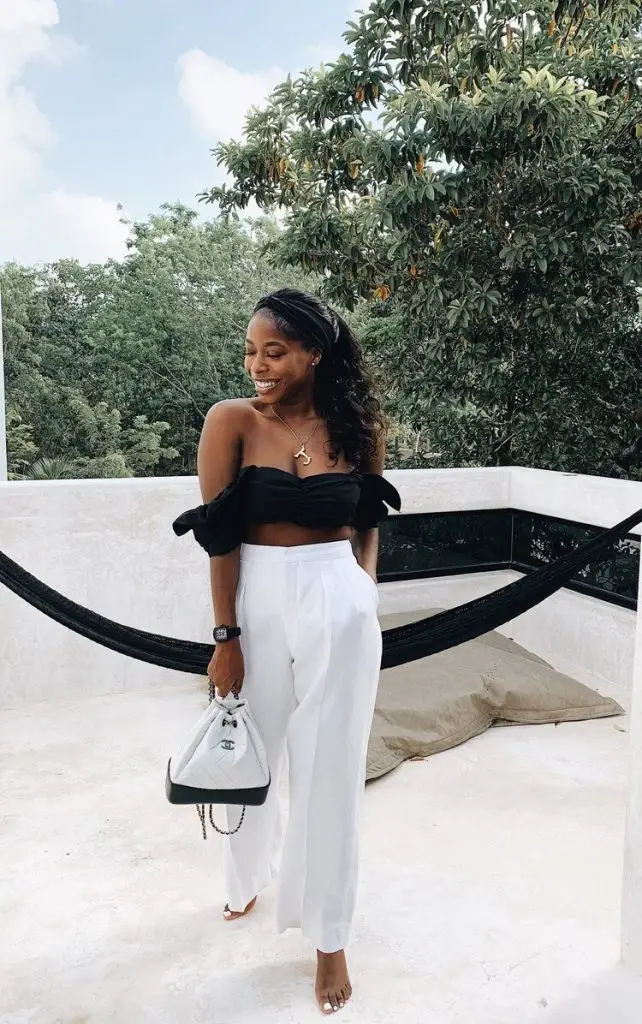 Black woman wearing camel wide-leg pants and a white crochet crop top